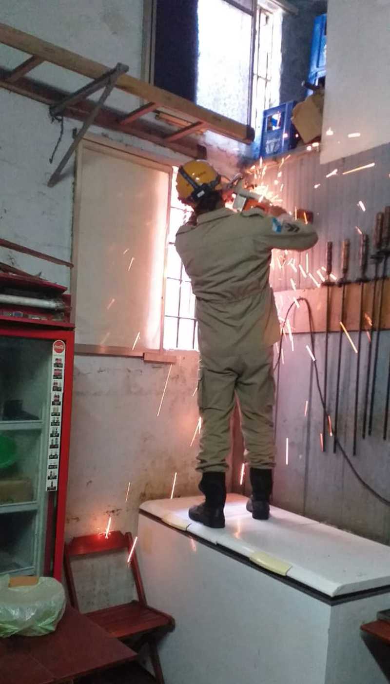 Janela precisou de um estabelecimento dentro de um dos prédios foi serrada para militares salvarem o animal — Foto: Corpo de Bombeiros/ Divulgação