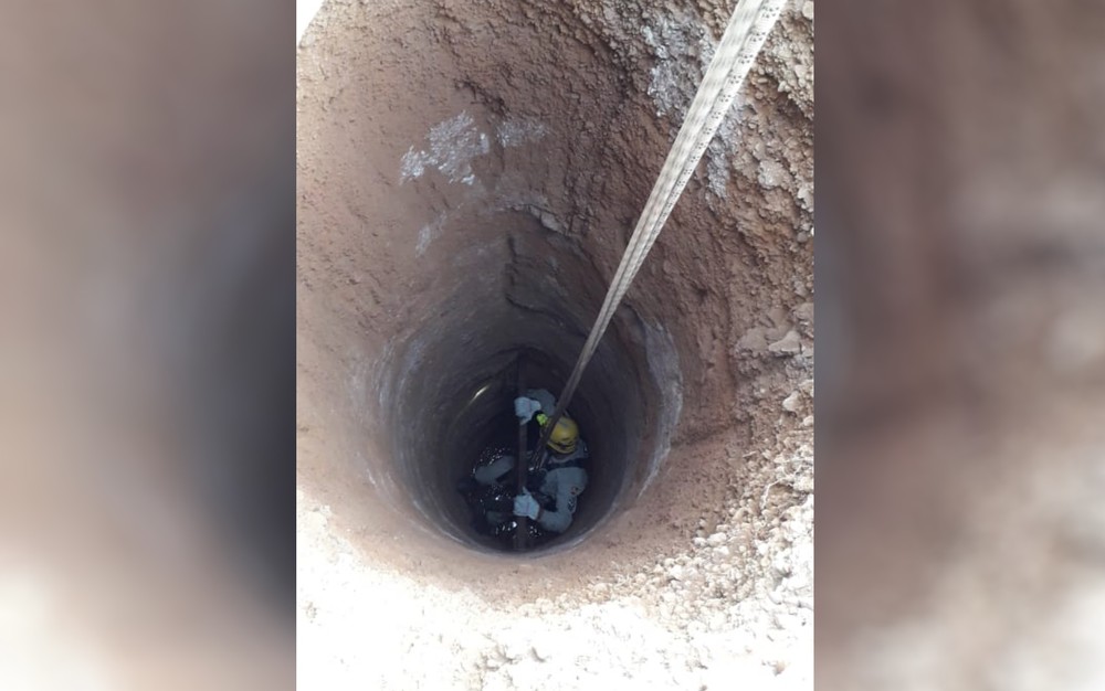 Militar desce até o fundo de cisterna para resgatar gato — Foto: Corpo de Bombeiros/Divulgação