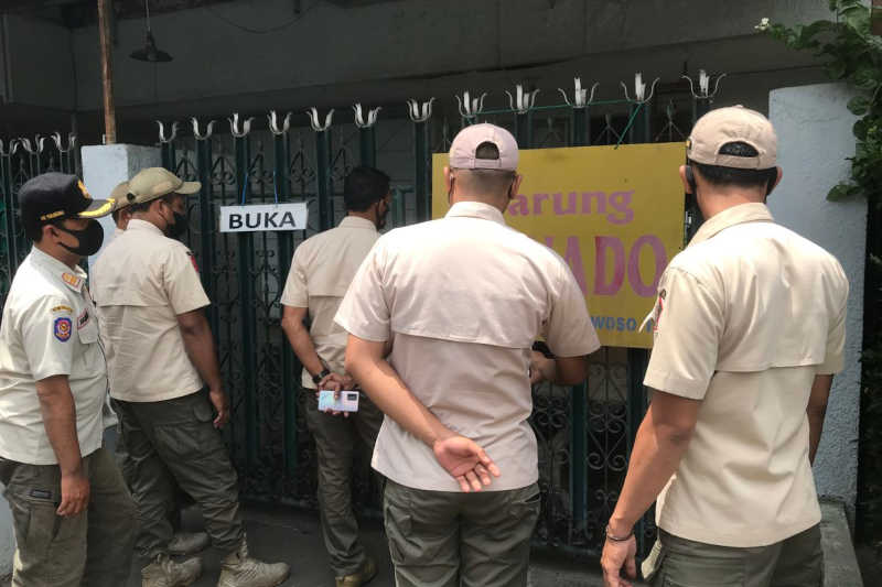 Agentes da ordem pública de Malang invadem um restaurante que serve carne de cachorro. Imagem de Eko Widianto/Mongabay Indonésia.