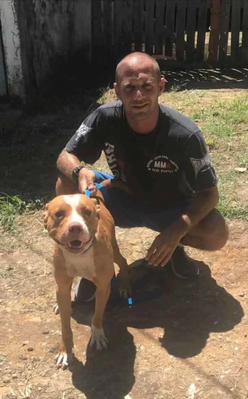 Gustavo com um cachorro que foi resgatado após ficar três meses amarrado em um poste. Imagem: Arquivo Pessoal