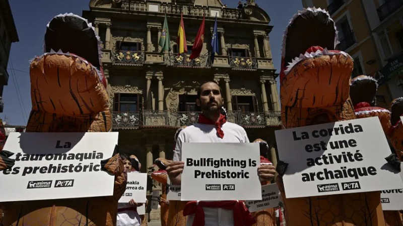 Ativistas vestidos de dinossauros protestam em Pamplona contra as largadas de touros