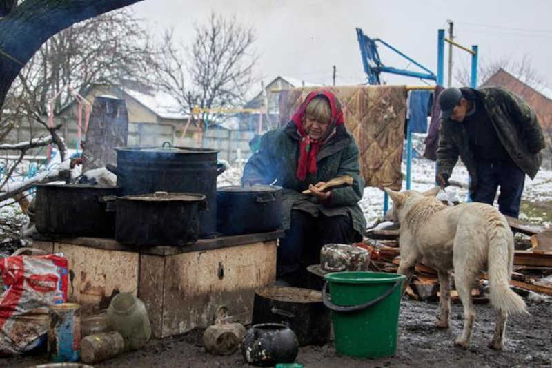 Em uma cozinha improvisado no meio da rua, a ucraniana cozinha um mingau para alimentar os cachorros. Foto: Sergiy Kozlov/EFE